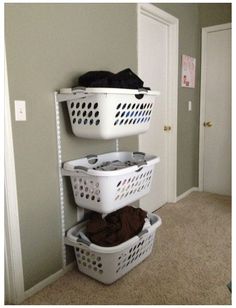 three laundry baskets stacked on top of each other in front of a door and closet