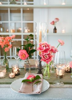 A cheerful tablescape set with glass bottles of bright pink camellia blooms, incredible tulips, sweet peas and ranunculus along with honey colored taper candles Tulip Tablescape, Pink Tablescape, Colored Taper Candles, Wedding Reception Signage, Pink Camellia, Tulip Wedding, Montreal Wedding, Wedding Branding, Wedding Reception Inspiration