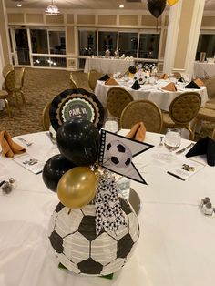 the table is set up for a soccer themed party with black, white and gold balloons