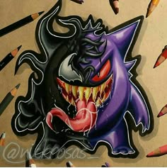 a drawing of a demon with sharp teeth and fangs on it's face, surrounded by crayon pencils