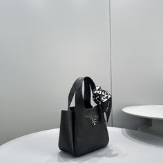 SHOP MORE LUXURY PRODUCTS HERE Description Prada Mini Tote Black For Women, Women’s Bags 7.5in/19cm This soft tote introduced for the Fall Winter 2020 collection presents a new interpretation of the triangle logo, traced by stitching with the Prada metal lettering logo illuminating its center. The reverse stitching emphasizes the soft, rounded silhouette that comes with a double handle and magnetic button closure. The nappa interior has three compartments. Size: 19 x 16 x 9 cm /7.5 x 6.3 x Designer Black Bucket Bag With Top Handle, Black Handheld Bag With Dust Bag Included, Designer Black Bucket Bag With Double Handle, Designer Black Bucket Bag For Errands, Black Top Handle Bucket Bag With Handle Drop, Black Top Handle Bucket Bag For Errands, Black Handheld Bucket Bag With Handle Drop, Handheld Black Bucket Bag, Prada Re Edition 2005