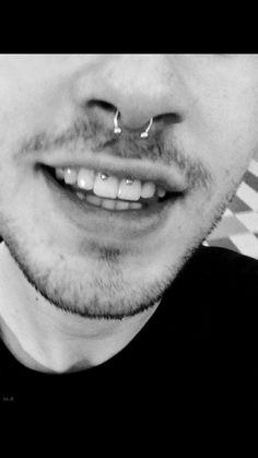 a man with piercings on his nose smiling