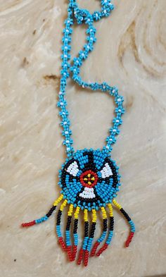 Beautiful hand beaded Navajo necklace. Multi colored with seed beads and leather backing. Chain is 13" long and medallion is 1 1/2" wide. Traditional Medallion Beaded Necklaces In Multicolor, Traditional Multicolor Medallion Beaded Necklaces, Traditional Multicolor Medallion Beaded Necklace, Beaded Medallion Necklace For Festivals, Southwestern Beaded Turquoise Necklace For Festival, Adjustable Medallion Beaded Necklaces For Festivals, Artisan Multicolor Medallion Beaded Necklaces, Artisan Multicolor Medallion Beaded Necklace, Multicolor Bohemian Medallion Beaded Necklaces