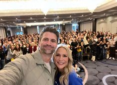 a man and woman taking a selfie in front of an audience