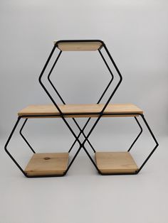 three wooden shelves stacked on top of each other with black metal frames and wood tops