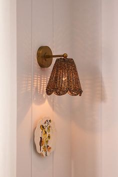 a lamp that is on the side of a wall next to a plate and bowl