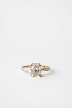 a yellow and white diamond engagement ring on a white background