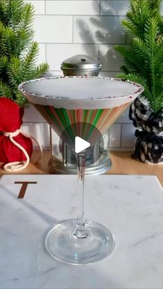 a martini glass sitting on top of a counter next to christmas decorations and greenery