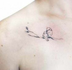 a small bird on a branch tattoo on the chest