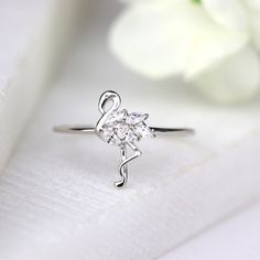 ✩ Made of solid sterling silver and marked 925. Good for sensitive skin. ✩ White gold finish to add extra shine and ensure durability ✩ Finest diamond simulants ✩ Main stone carat weight: 2 ct ✩ Shank width 1 mm ✩ Approx. weight: 1.2 g ✩ Handmade in USA & Ship beautifully packaged We only choose the finest diamond simulants (CZ 5A) on the market, with a breathtaking level of brightness like real diamonds. Our jewelry can be found in stores and boutiques in Illinois, Indiana and Wisconsin. We Elegant Silver Rings For Birthday, Flamingo Ring, Bird Ring, Bird Rings, Tropical Bird, Diamond Simulant, Tropical Birds, Ring Dainty, Dainty Ring