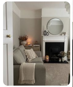 a living room filled with furniture and a fire place in front of a white fireplace