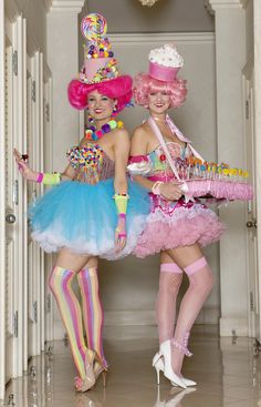 two women dressed in colorful costumes standing next to each other with candy on their feet