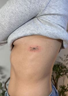 a woman with a small tattoo on her stomach