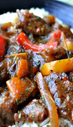 a close up of a plate of food with meat and vegetables on top of rice