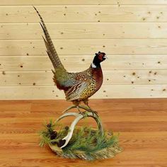 a statue of a pheasant standing on top of a wooden table