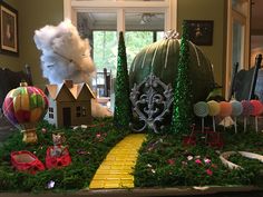 a table topped with lots of green plants and decorations on top of it's sides