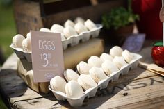 an egg carton with eggs in it sitting on a table next to some strawberries