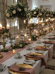 a long table is set with plates and candles for an elegant dinner or party event