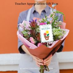 a woman holding a bouquet of flowers with a teacher appreciation gift tag