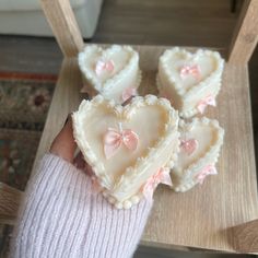 a person holding three heart shaped cookies in their hands