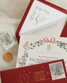 two envelopes with christmas stamps on them next to a penny and some other items