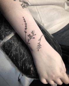 a woman's foot with a tattoo on it that has flowers growing out of it