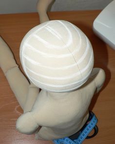 a white stuffed animal sitting on top of a wooden table