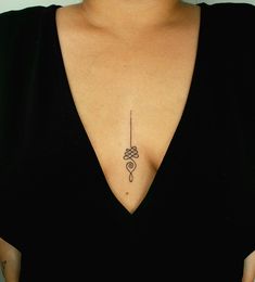 a woman with a tattoo on her chest holding a cell phone in one hand and a pen in the other