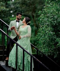 a man and woman standing on top of a set of stairs