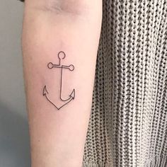 a small anchor tattoo on the arm