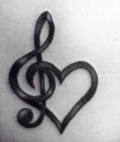 a treble and heart tattoo on the back of a woman's shoulder,