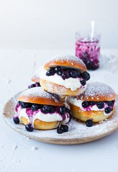 blueberry bagels with cream cheese and powdered sugar on a wooden platter