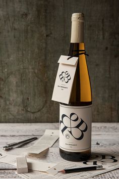 a bottle of wine sitting on top of a wooden table next to scissors and paper