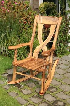 a wooden rocking chair sitting in the grass