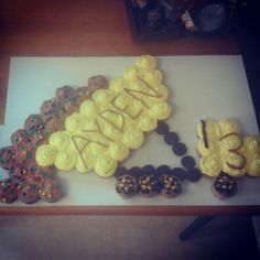 a table topped with lots of cupcakes on top of a white cutting board