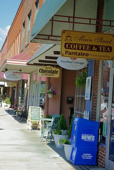 there are many shops along this street with signs on the front and side of them