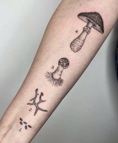 a mushroom and starfish tattoo on the left inner arm, with an ink splotch