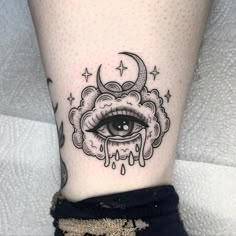 a woman's leg with an all seeing eye tattoo on it