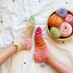 two hands with socks and balls of yarn