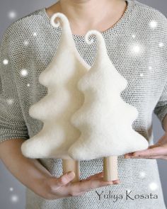 a woman holding a small white felt christmas tree