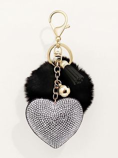 a heart shaped bag charm with a tassel hanging from it