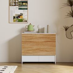 a wooden cabinet sitting on top of a hard wood floor next to a potted plant