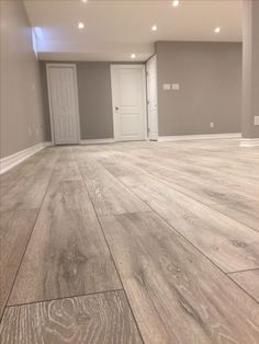 an empty room with wood floors and white doors