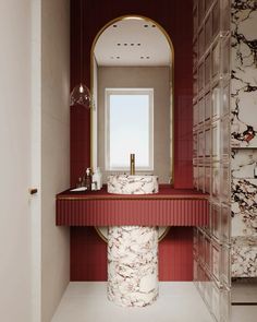 a bathroom with marble counter tops and red walls