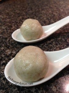 two white spoons filled with food on top of a counter