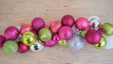 a bunch of ornaments that are sitting on a wooden table, all in different colors