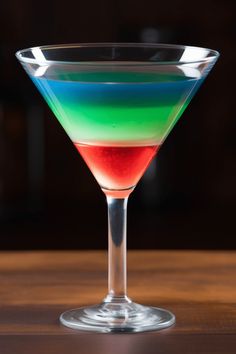 A colorful Nuclear Rainbow cocktail showcases vibrant layers. This pin illustrates how to create the perfect this cocktail consisting of Midori, vodka, Jagermeister, and grenadine, making it a striking choice for parties. Rumple Minze, Rainbow Cocktail, Basil Smash, Rainbow Drinks, Campari And Soda, Layered Drinks, Green Ghost