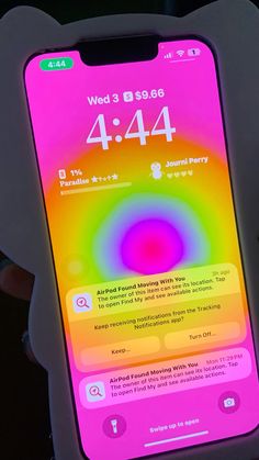 someone is holding up an iphone with the time displayed on its screen and it's color changing