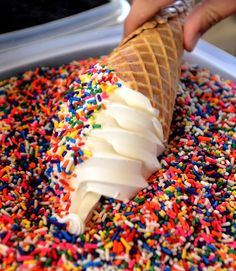 an ice cream cone with sprinkles and white frosting