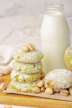 cookies and almonds on a wooden board next to a bottle of milk